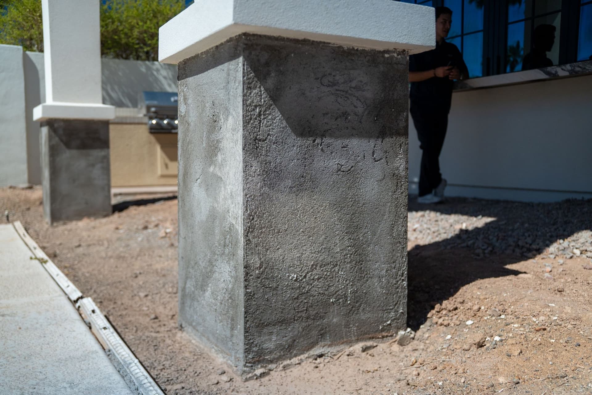 Rough stucco base coat on an exterior column before the finish coat