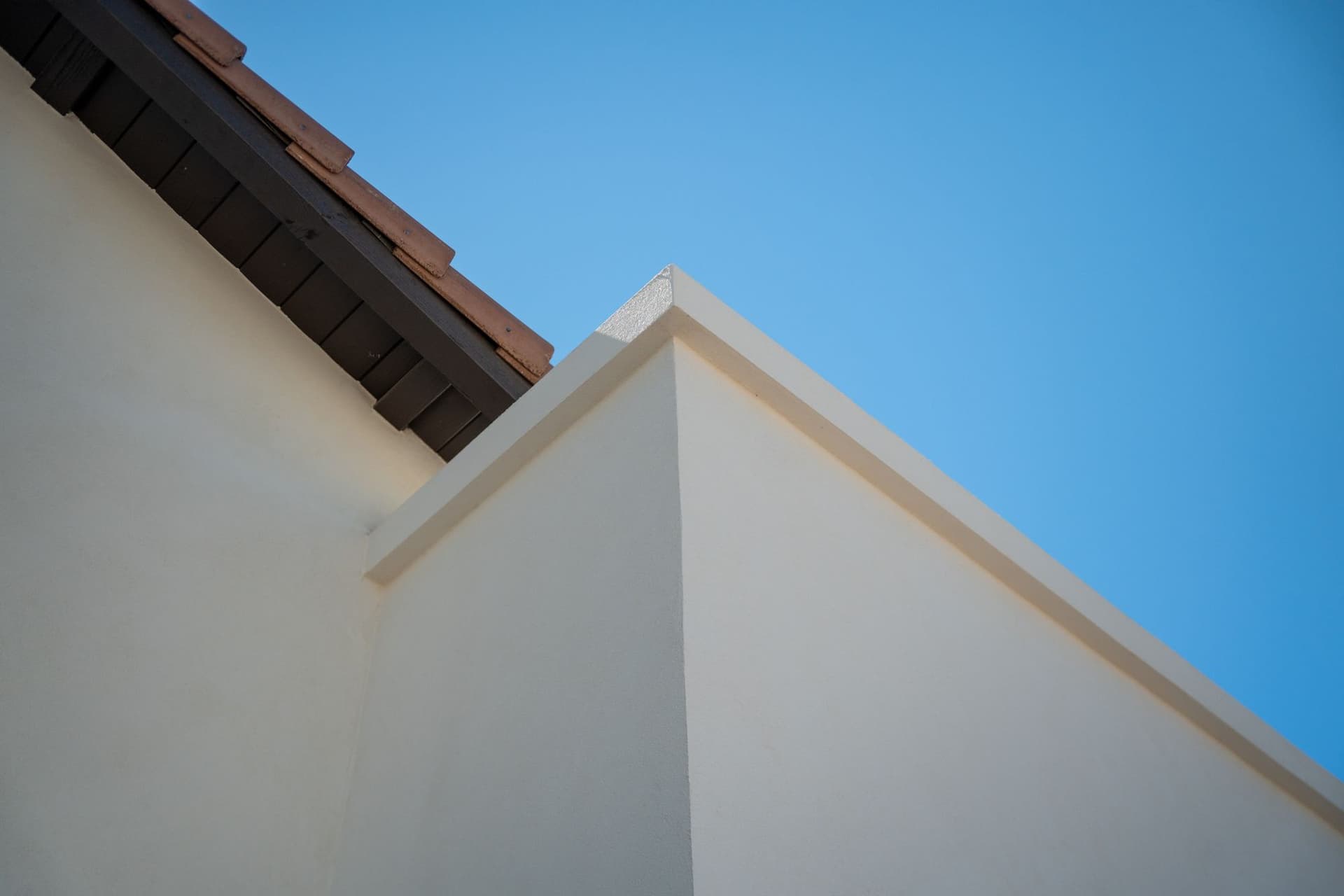White stucco gable beneath tiled eaves and dark fascia