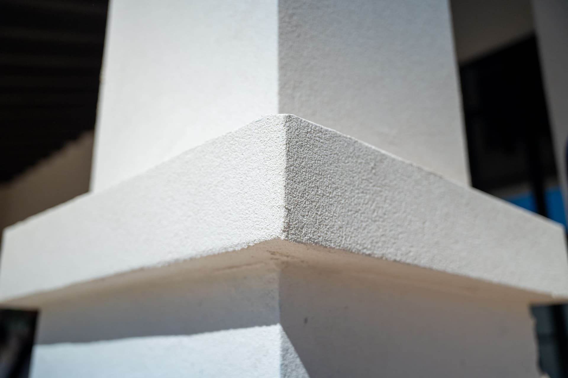 Finished white stucco corner and trim on an exterior column